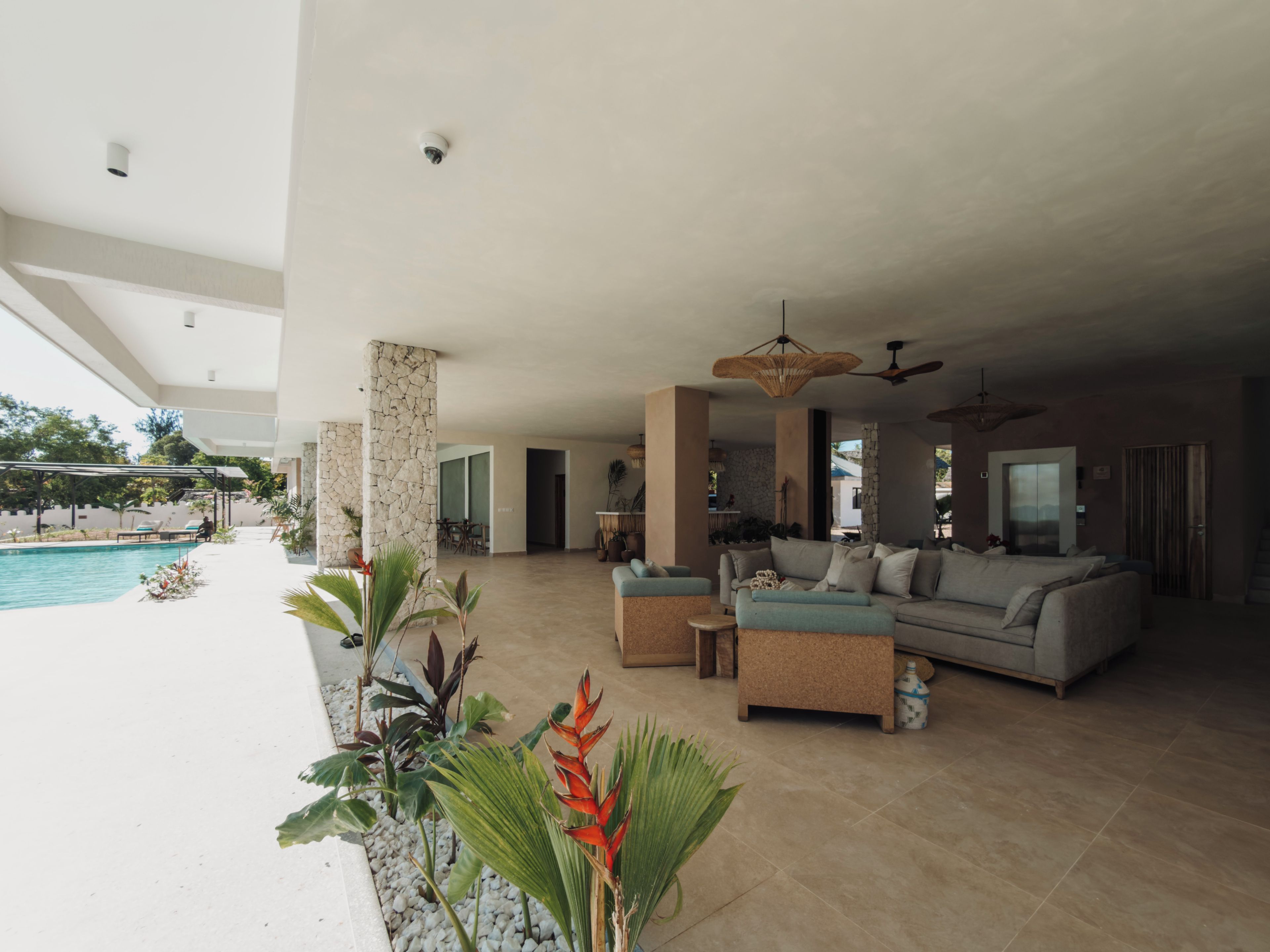 Un vaste espace de vie avec piscine, coin salon extérieur et vue sur la piscine.