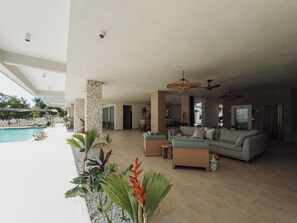 Amplia sala de estar con piscina, mobiliario exterior y vistas a la piscina.