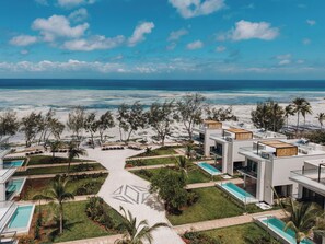 Un resort con arquitectura moderna, múltiples piscinas y vista al mar.