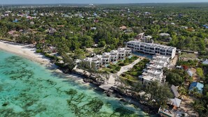 Un complexe hôtelier comprenant plusieurs bâtiments, une plage et des espaces verts environnants.