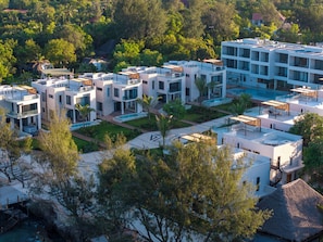 Un moderno resort con varias edificaciones, piscinas al aire libre y abundante vegetación.