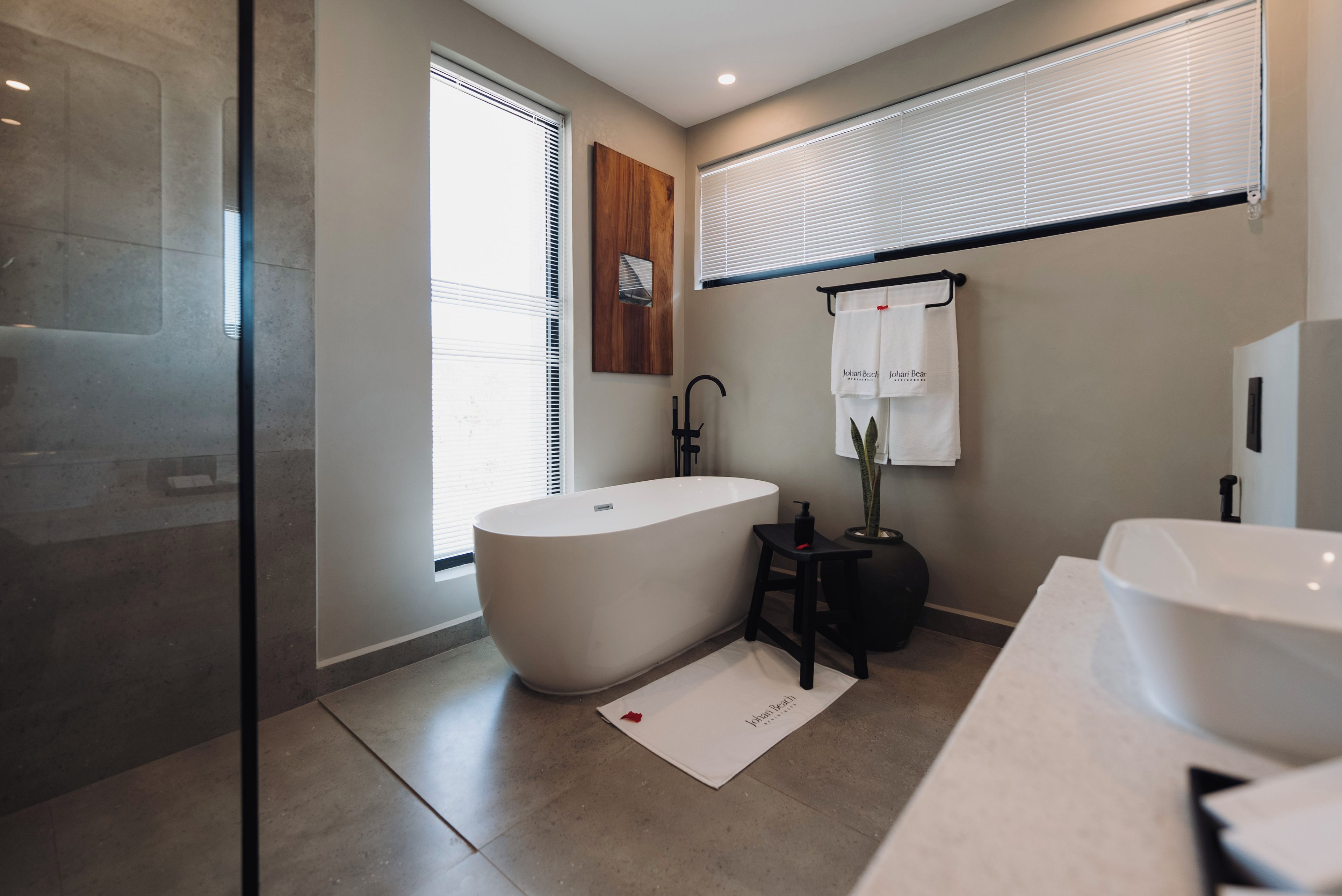 Een moderne badkamer met een vrijstaand bad, een wastafelmeubel en een douchehoek.