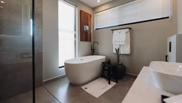 Een moderne badkamer met een vrijstaand bad, een wastafelmeubel en een douchehoek.