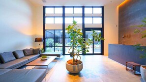 Ein modernes Interieur mit einer Couch, einem Couchtisch und einer Topfpflanze.