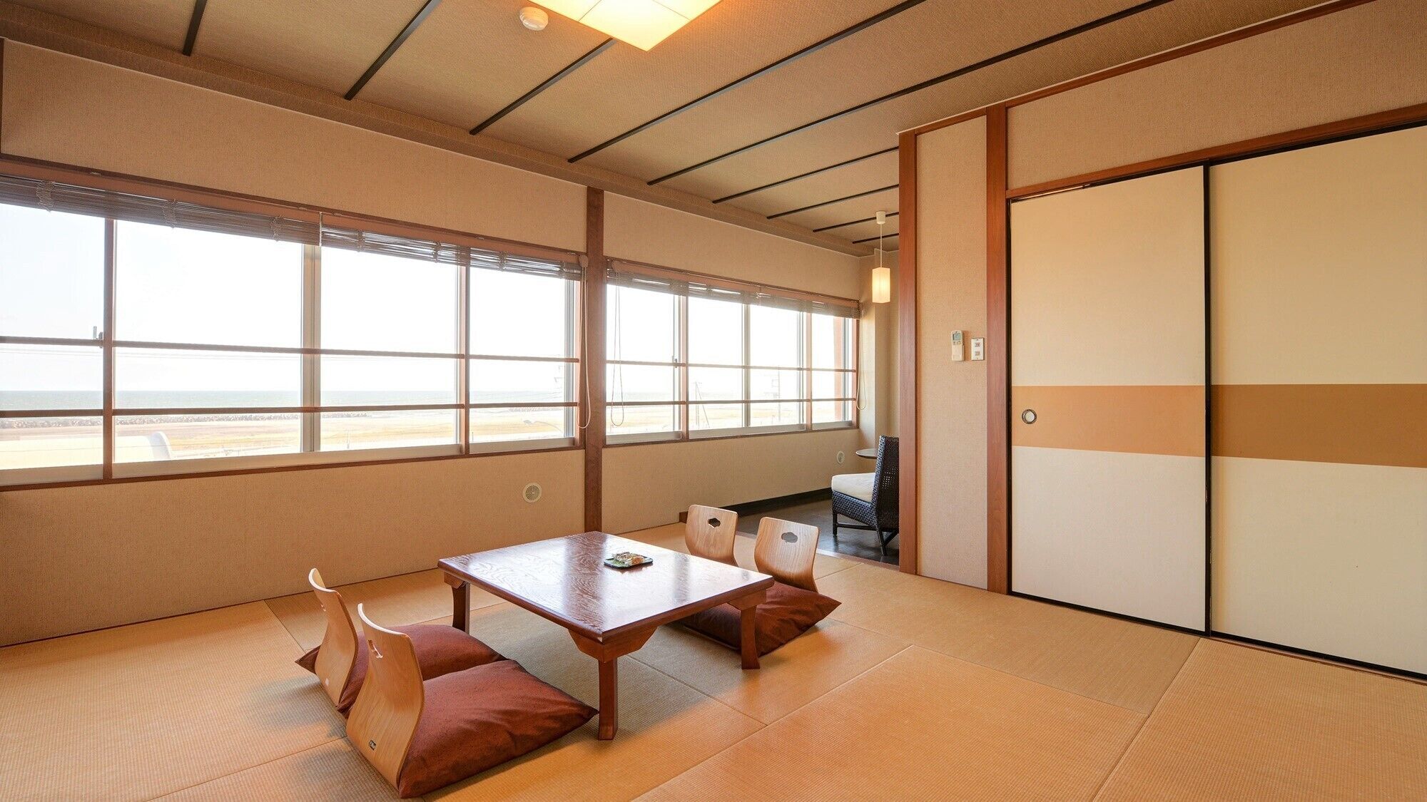 A traditional Japanese room with tatami flooring, a low table, and sliding doors.
