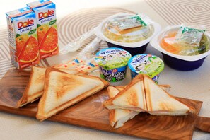 A meal with toast, orange juice, and packaged food items.