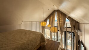 A bedroom with a large bed, a balcony with curtains, and a view of the beach. - Oasis Village (Eforie)