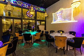 A restaurant with tables set for dining, chairs, and chandeliers. - Czeczotka Palace Apartments (Kraków)