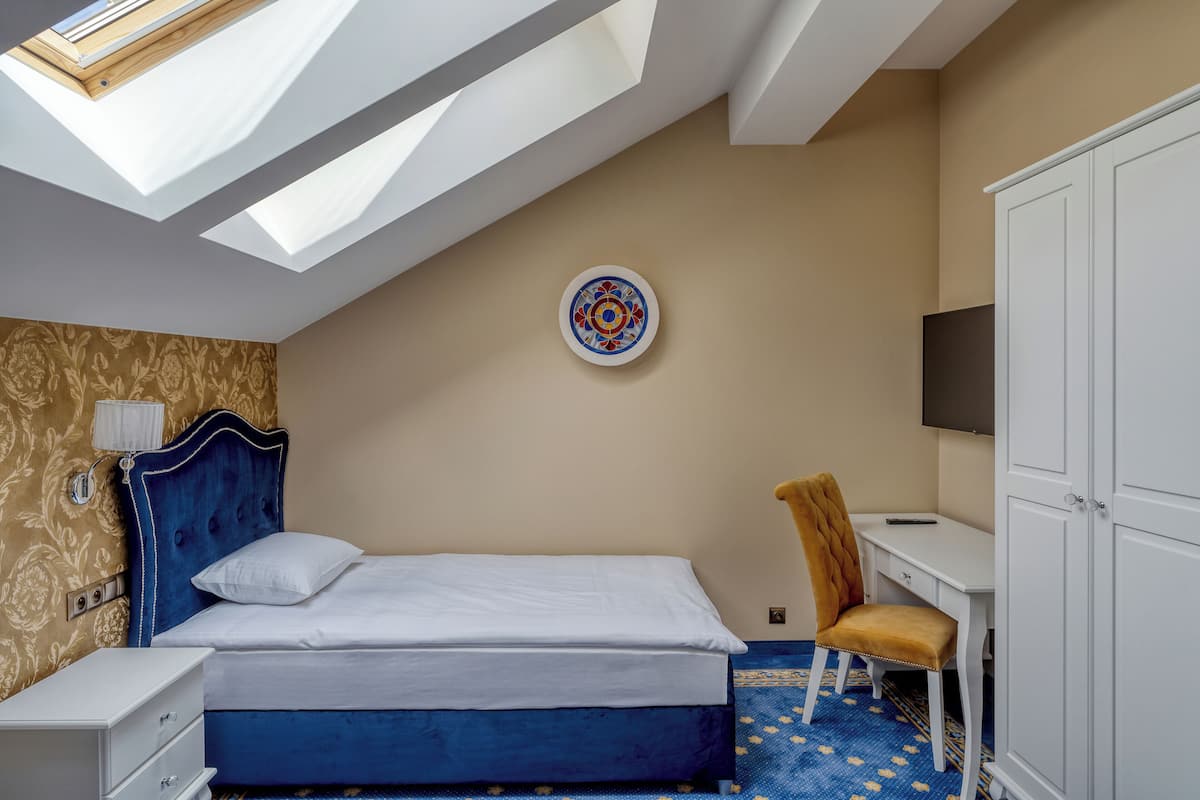 Une chambre à coucher avec un lit, un bureau, une chaise et une armoire.