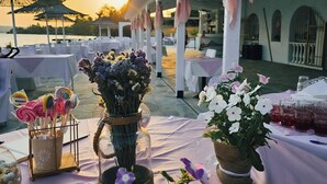 A table set for a meal with a view of the sunset, decorated with flowers and lollipops. - Paradise Resort Evia (Eretria)