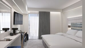 A modern hotel room with a bed, a desk with a computer, a TV, and a window with curtains. - Paradise Resort Evia (Eretria)