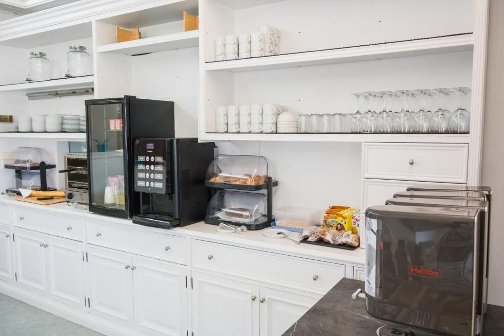 Uma cozinha compacta com máquina de café, torradeira e geladeira.