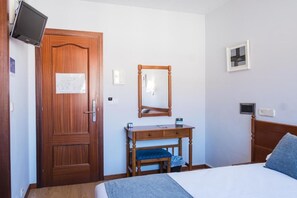 Egy szállodai szoba, melyben van egy fa ajtó, egy ágy, egy tükörrel ellátott éjjeliszemélyzet, egy kis íróasztal és egy a falra szerelt televízió.