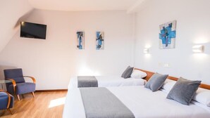 A hotel room with two beds, a flat-screen TV, and artwork on the walls. - Alda Arteixo (Abegondo)