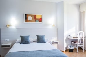 A modern hotel room with a bed, bedside tables, a desk, and a chair. - Alda Arteixo (Abegondo)