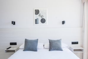 A modern hotel room with a large bed, two bedside tables, a wall-mounted artwork, and a nightstand with a remote control. - Alda Arteixo (Abegondo)