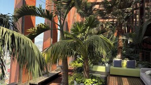 Un jardin sur le toit, doté d’un sol en bois, d’espaces aménagés pour s’asseoir et de différentes plantes.