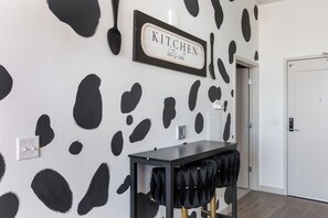 A kitchen area with a sign that reads "KITCHEN let's eat" and a wall with a black and white abstract pattern. - Luxury High-Rise, Walk to Broadway, Pool + Sky Lounge, coffee essentials (Nashville)