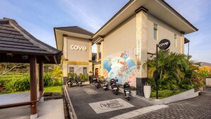 Un edificio con un murale, un cartello che indica 'cove' e un'area di parcheggio con motociclette.