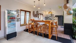 Una cucina moderna con isola centrale, sgabelli da bar, frigorifero e forno a microonde.