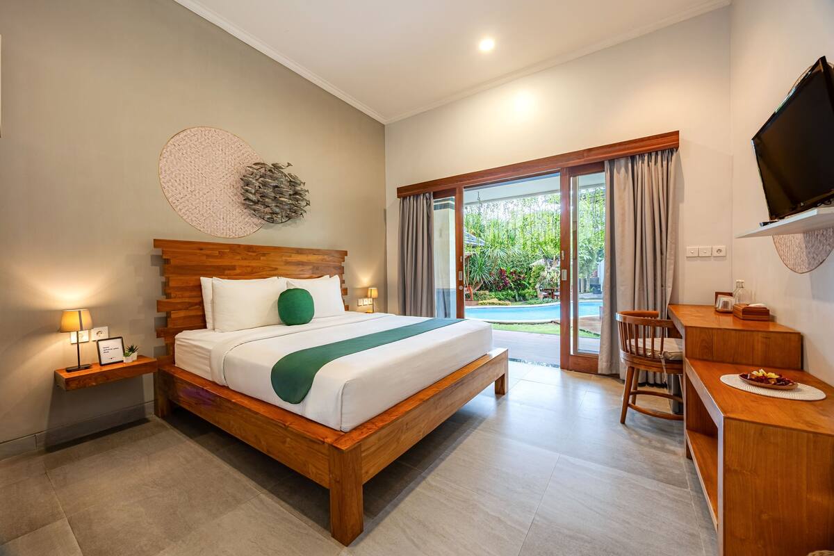 Une chambre d’hôtel moderne avec un lit en bois, un bureau et un téléviseur.