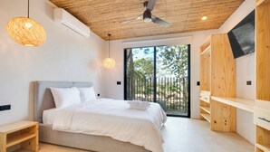 Ein modernes Schlafzimmer mit einem großen Bett, Holzboden und einer Schiebeglasdoor zum Außenbereich.