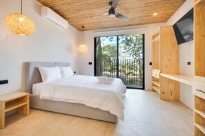 A modern bedroom with a large bed, wooden ceiling, and a sliding glass door to the outside. - Spacious 4-Bed Home with Stunning Outdoor Living (Playa Flamingo)
