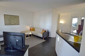 A modern living room with a sofa, a coffee table, and a flat-screen TV.