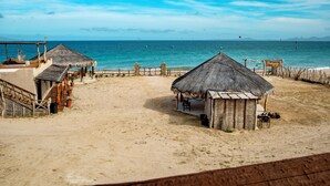Una platja amb cabanes de palla i una tanca de fusta.