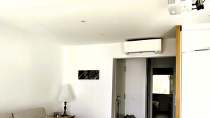 En stue med sofa, lampe og et billede på væggen.