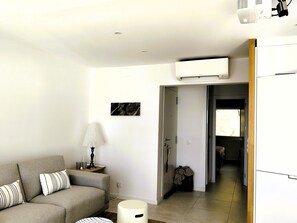 Ein Wohnzimmer mit einer Couch, einer Lampe und einem Bild an der Wand.