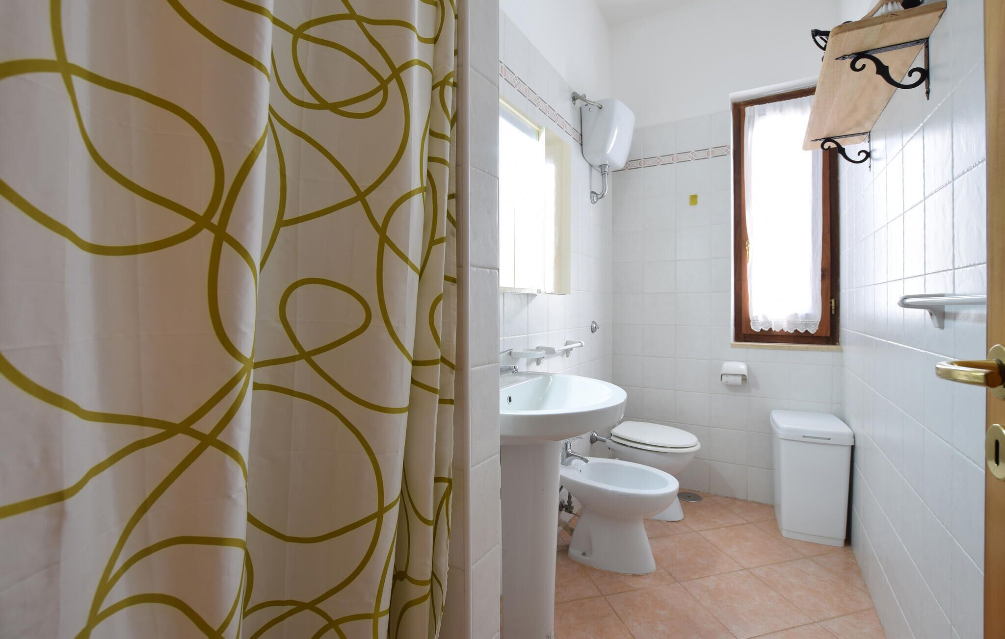 A bathroom with a toilet, bidet, and sink.