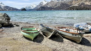 Three boats on a rocky shore by a lake with mountains in the background. - La Solina Lunghin by Interhome (Maloja)