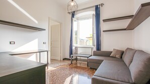 Un saló modern amb un sofà, una taula petita i un penjador de llum.