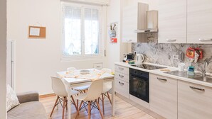 Een moderne keuken met een eethoek, voorzien van een raam, een waterkoker en een koffieapparaat.