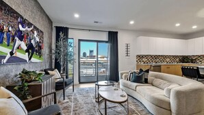 A modern living room with a sofa, a coffee table, and a TV mounted on the wall. - Hyve-Anthem-Private Balconies-Walk to Broadway (Nashville)