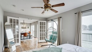 Una habitación amplia con una cama grande, un sillón colgante y vistas a un balcón.