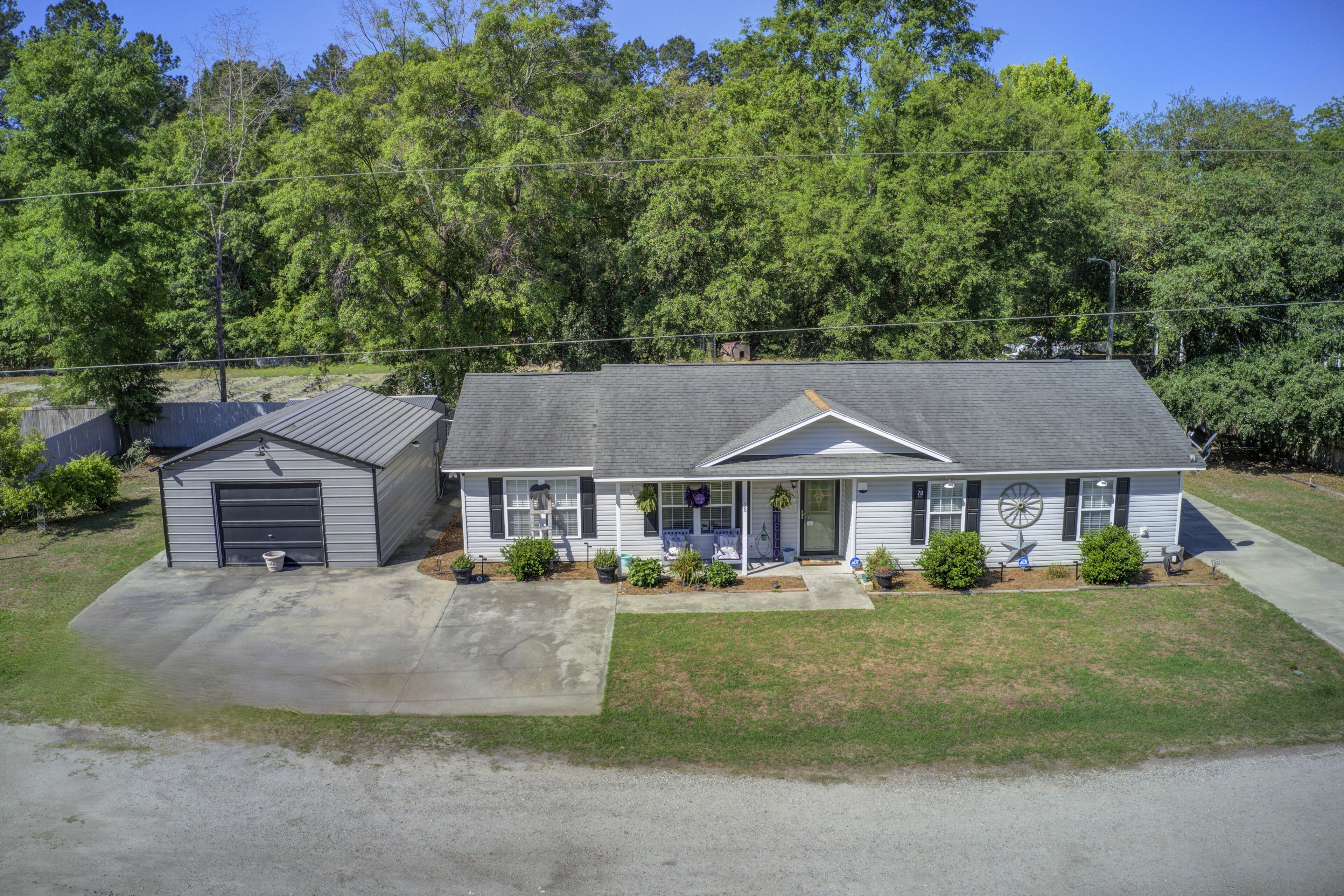 A single-story house with a garage, a front porch, and a small attached shed.