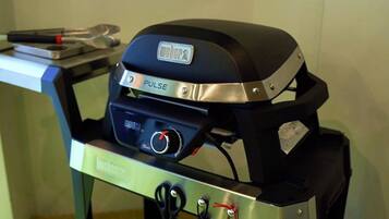Un barbecue Weber Pulse doté d’un écran numérique, de boutons de commande et d’une poignée.
