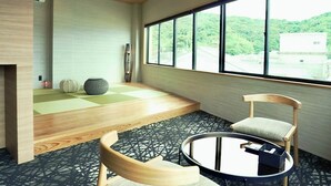 A modern interior with a large window, a wooden floor, a round table, and a chair. - 1 and Only Hotel Io (Minamiise)