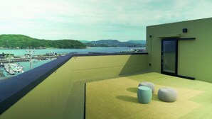 A balcony with a view of a marina and hills. - 1 and Only Hotel Io (Minamiise)