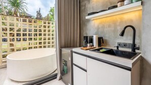 Un bagno moderno con una vasca freestanding, un lavabo compatto e una macchina per caffè integrata.