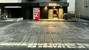 Um hotel moderno com fachada escura, diversas janelas e uma placa indicando 'RUKA Hotel'.