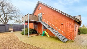 A red brick building with a metal staircase leading to a covered porch. - Amazing apartment in Nørre Nebel (Nørre Nebel)