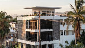 A modern building with a two-story structure, large windows, and a flat roof. - Loft 2 min walk from the Marina CSL (Cabo San Lucas)