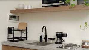 A kitchen with a built-in sink, a coffee maker, and a microwave on an upper shelf. - Loft 2 min walk from the Marina CSL (Cabo San Lucas)