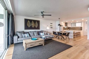 Un salon moderne avec un canapé, une table basse et un coin repas.