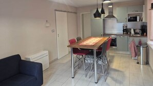 Een compact woongedeelte met een eethoek, kitchenette en een afzonderlijke zithoek.