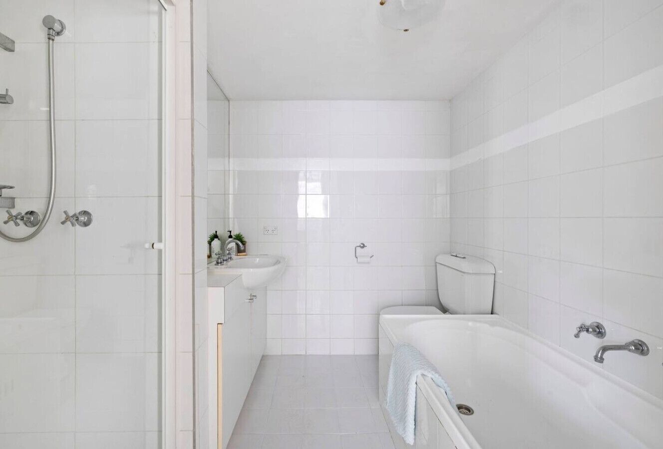 A modern bathroom with a shower, sink, toilet, and bathtub.