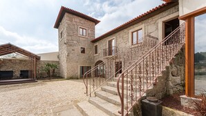 Ein Gebäude aus Stein mit einer Treppe und einer Außen-Sitzgelegenheit.